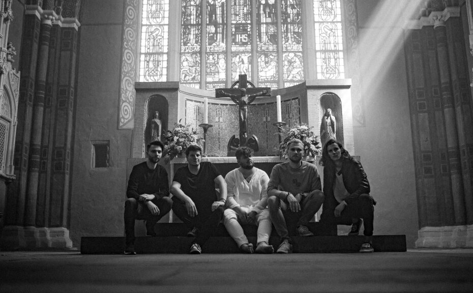 Schwarz-weiß-Foto in der Kirche: Die fünfköpfige Band stitzt vor dem Altar