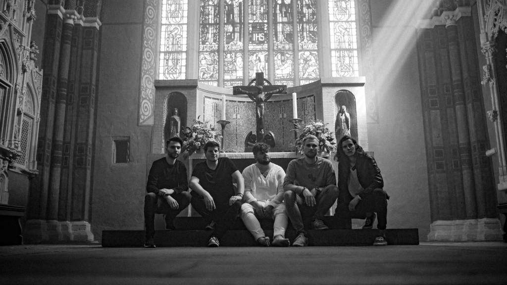Schwarz-weiß-Foto in der Kirche: Die fünfköpfige Band stitzt vor dem Altar